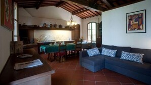 Un interior rústico con comedor, sofá y cocina con encimera de mármol.