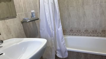 Bañera, secador de pelo, toallas y jabón