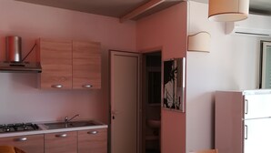 Une cuisine moderne avec des meubles en bois, une cuisinière encastrée et un coin repas comprenant une table et des chaises.