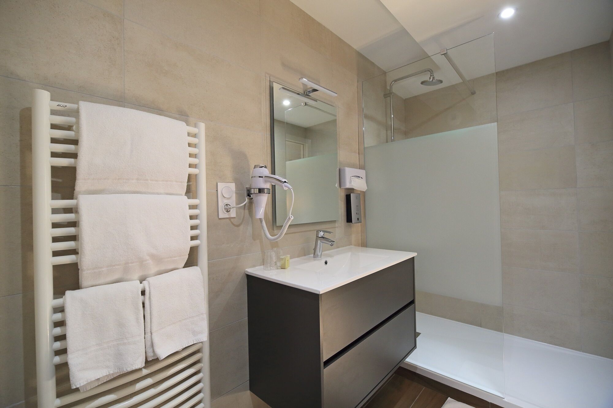 A modern bathroom with a built-in towel rack, a mirror, a sink, and a shower.