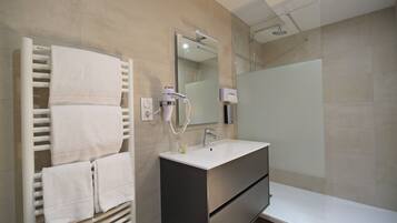 A modern bathroom with a built-in towel rack, a mirror, a sink, and a shower.