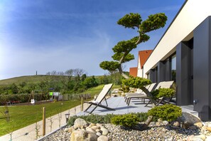 A modern house with a patio area, outdoor seating, and a well-maintained garden.