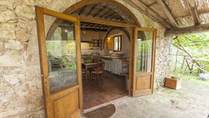 Un edificio rústico de piedra con puertas de madera que dan a una cocina y comedor.