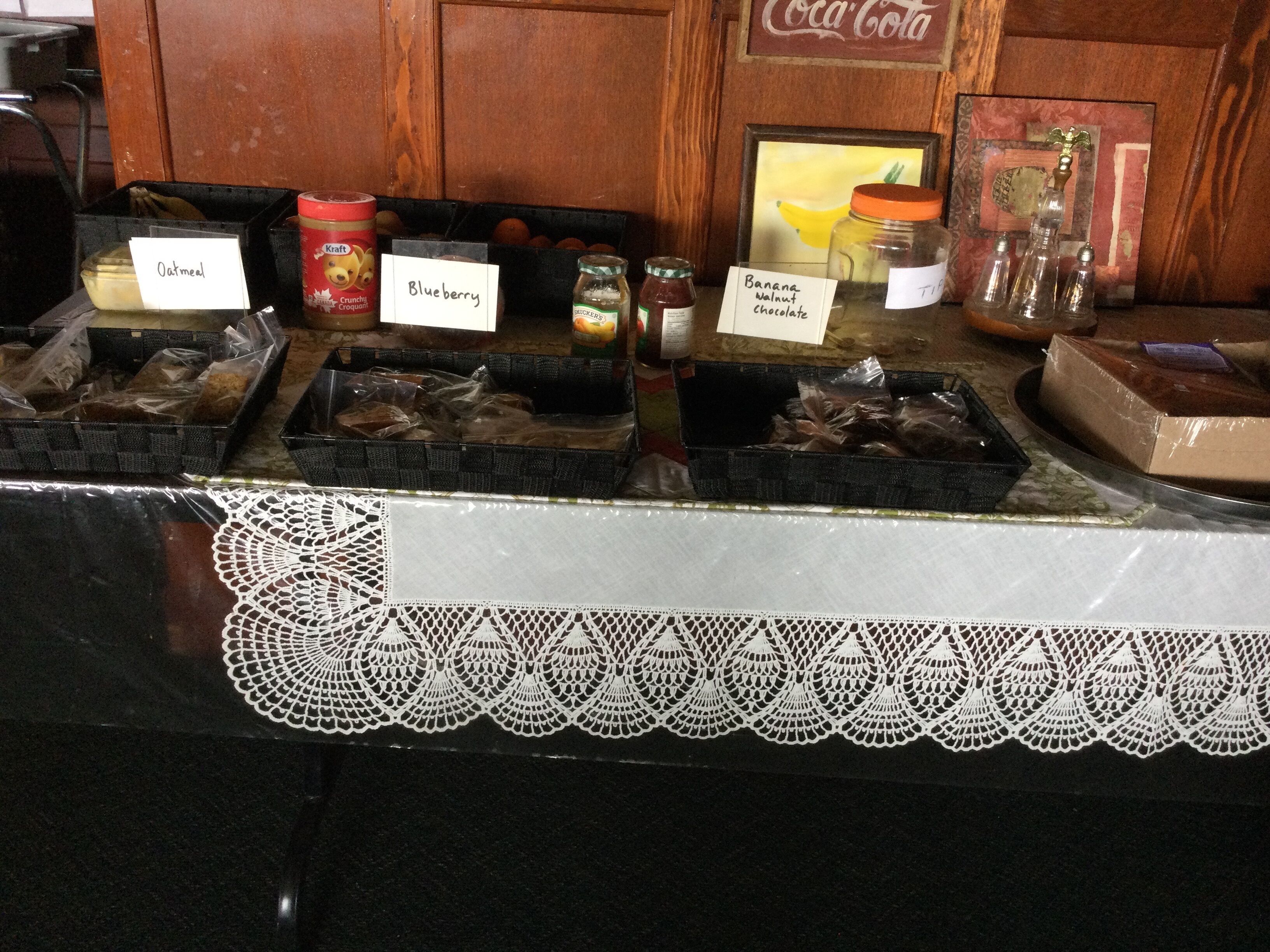 A food display with labeled containers of oatmeal, blueberry, and banana walnut chocolate.