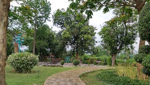 A paved pathway in a park with trees and greenery. - Saichonview Resort (Kanchanaburi)