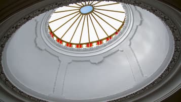 A dome with a central oculus, ornate gold and red detailing, and a white interior.