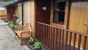 A wooden building with a porch, a bench, and a sign indicating a dining room. - Red Lion Inn (Wooler)