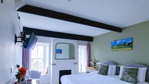 A bedroom with a bed, bedside table, lamp, and a painting on the wall. - Red Lion Inn (Wooler)