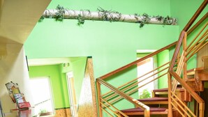 Una escalera con barandillas de madera y peldaños alfombrados de color verde.