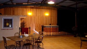 An indoor dining area with a wooden wall, a small table with chairs, and a railing. - Domaine de la Bellière (Villars-les-Dombes)