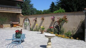 A courtyard with a fountain, a bench, and potted plants. - Domaine de la Bellière (Villars-les-Dombes)