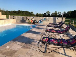 Ein Schwimmbecken mit Liegestühlen und einer Sonnenterrasse.