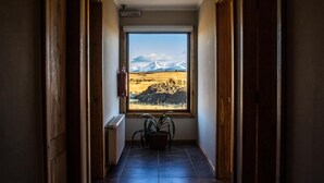 Ein Flur mit einem großen Fenster und Blick auf eine gebirgige Landschaft.
