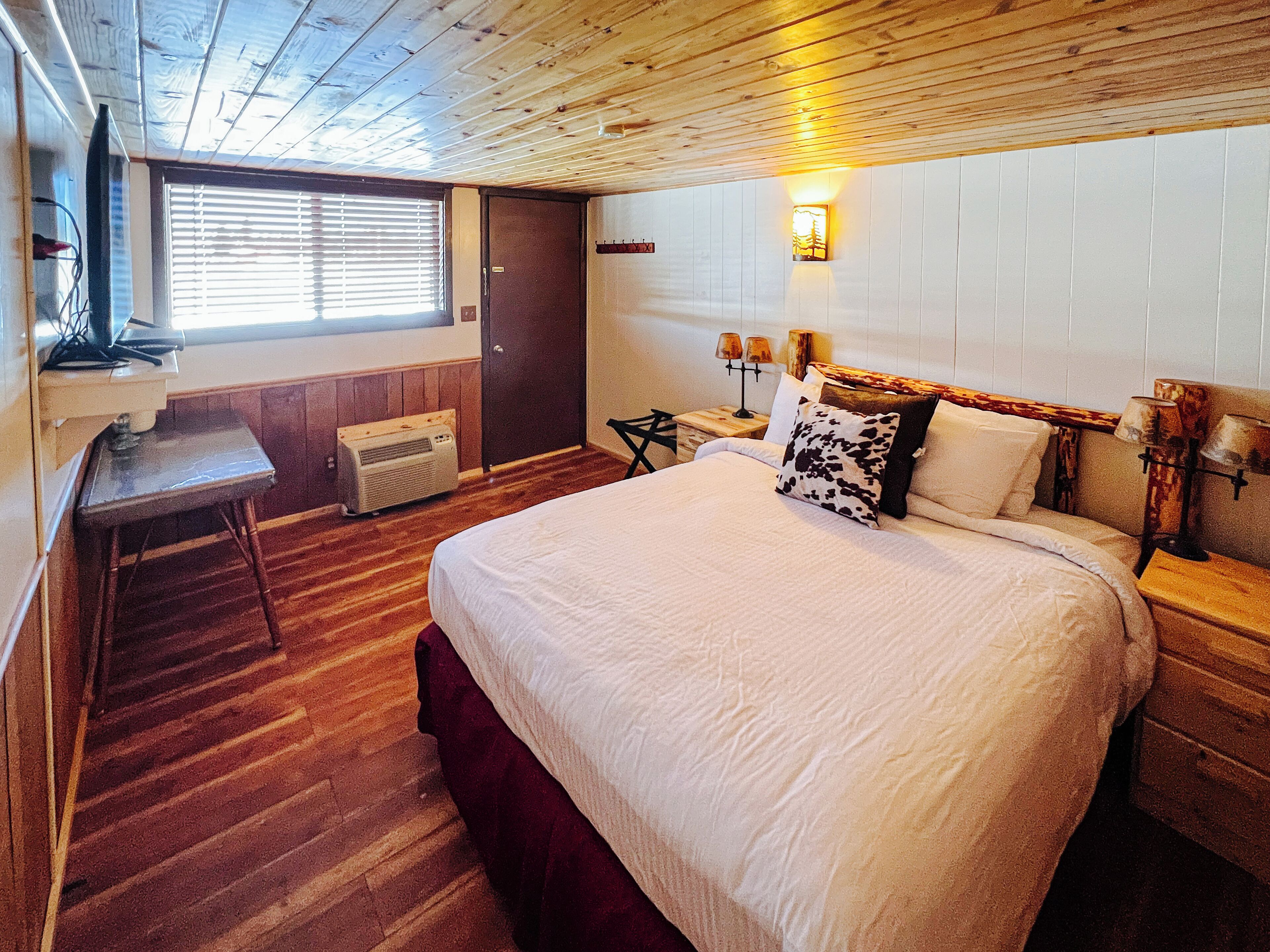 Een kamer met een bed, een bureau en een verwarming.