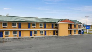 Un motel composé d’un bâtiment à deux étages, de plusieurs chambres et d’un parking.