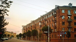Useita kerroksia sisältävä tiilirakennus, jonka pohjakerroksessa on rivi ikkunoita. Todennäköisesti kyseessä on hotelli tai asuintalo.