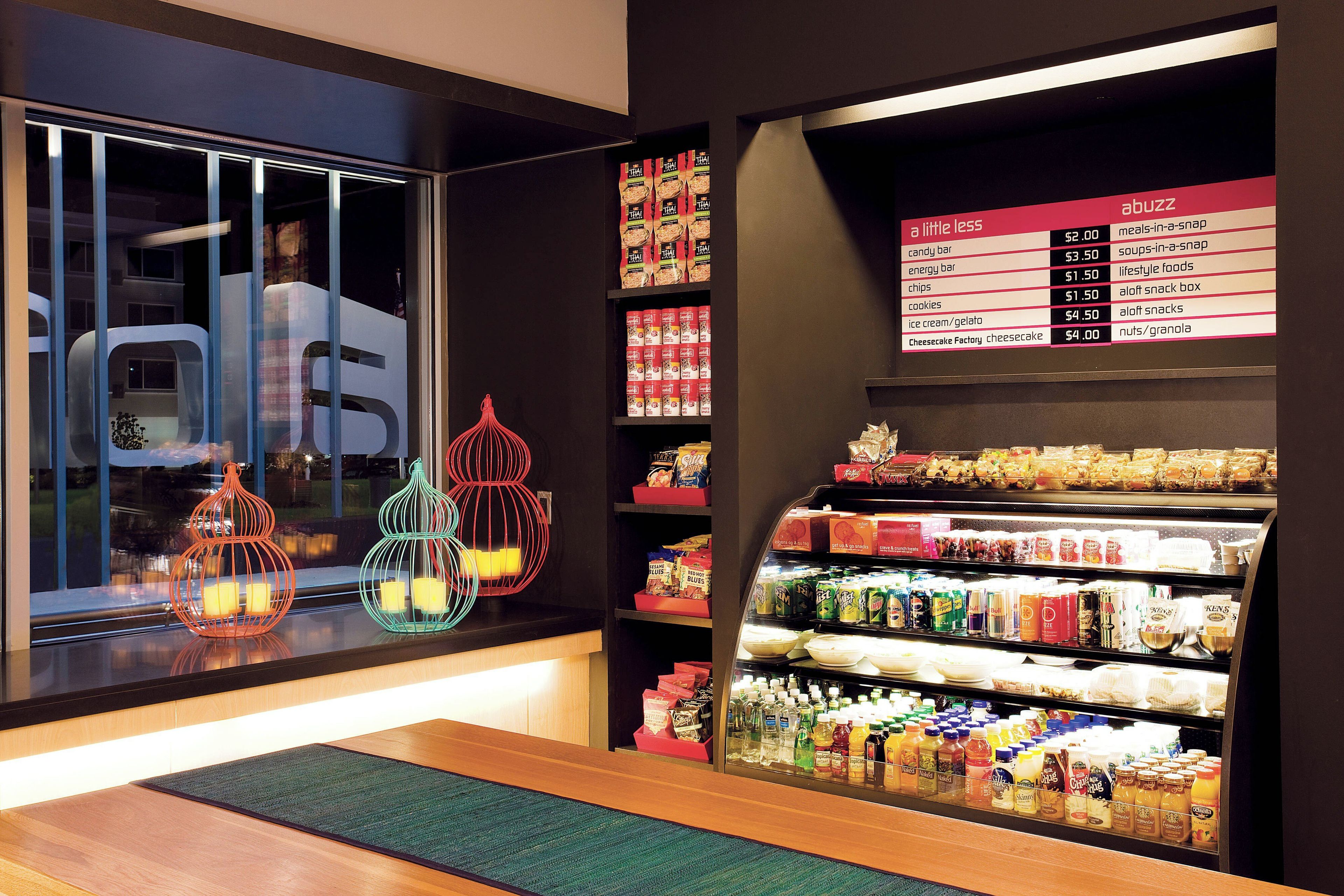 A hotel room with a minibar, a snack bar, and a view of the street outside.