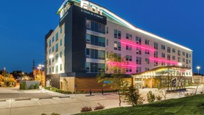 A modern hotel with a prominent 'Elow' sign, a well-lit entrance, and a landscaped outdoor area. - Aloft by Marriott Dallas Arlington Entertainment District (Arlington)