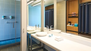 A modern bathroom with two sinks, a large mirror, and a shower area. - Aloft by Marriott Dallas Arlington Entertainment District (Arlington)