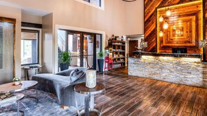 A spacious lobby with a modern bar area, comfortable seating, and a large window providing natural light.