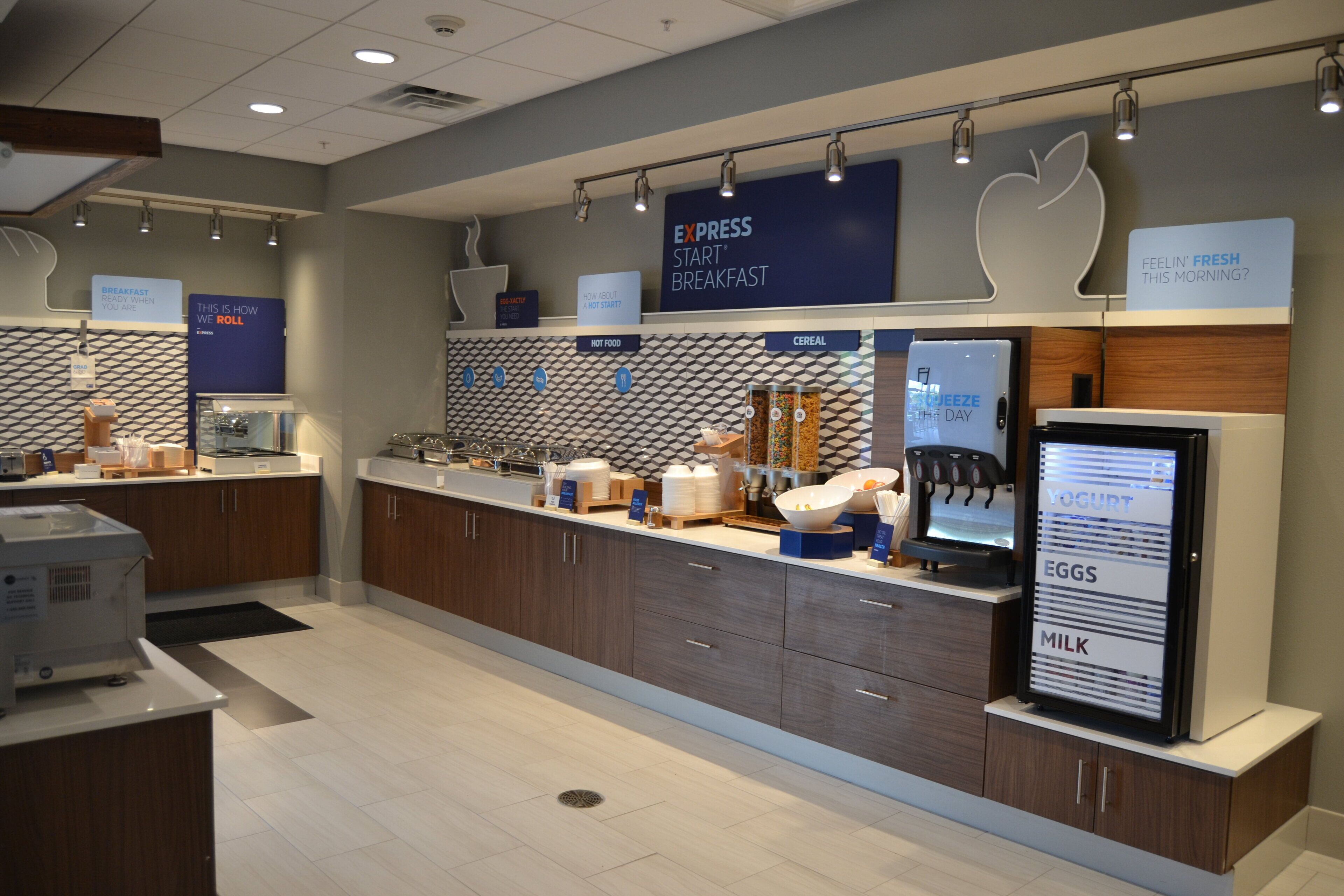 A breakfast area with a self-serve station, including options for eggs, milk, cereal, and hot food.
