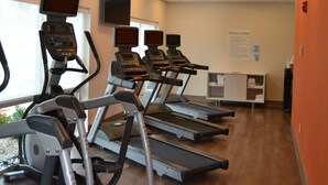 Ein Fitnessraum mit Laufbändern, einem an der Wand montierten Fernseher und einem Schild, das den Zweck des Raumes erklärt.