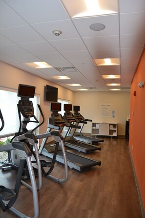 A fitness center with treadmills, a wall-mounted TV, and a sign indicating the room's purpose. - Holiday Inn Express & Suites Goodlettsville N - Nashville by IHG (Goodlettsville)