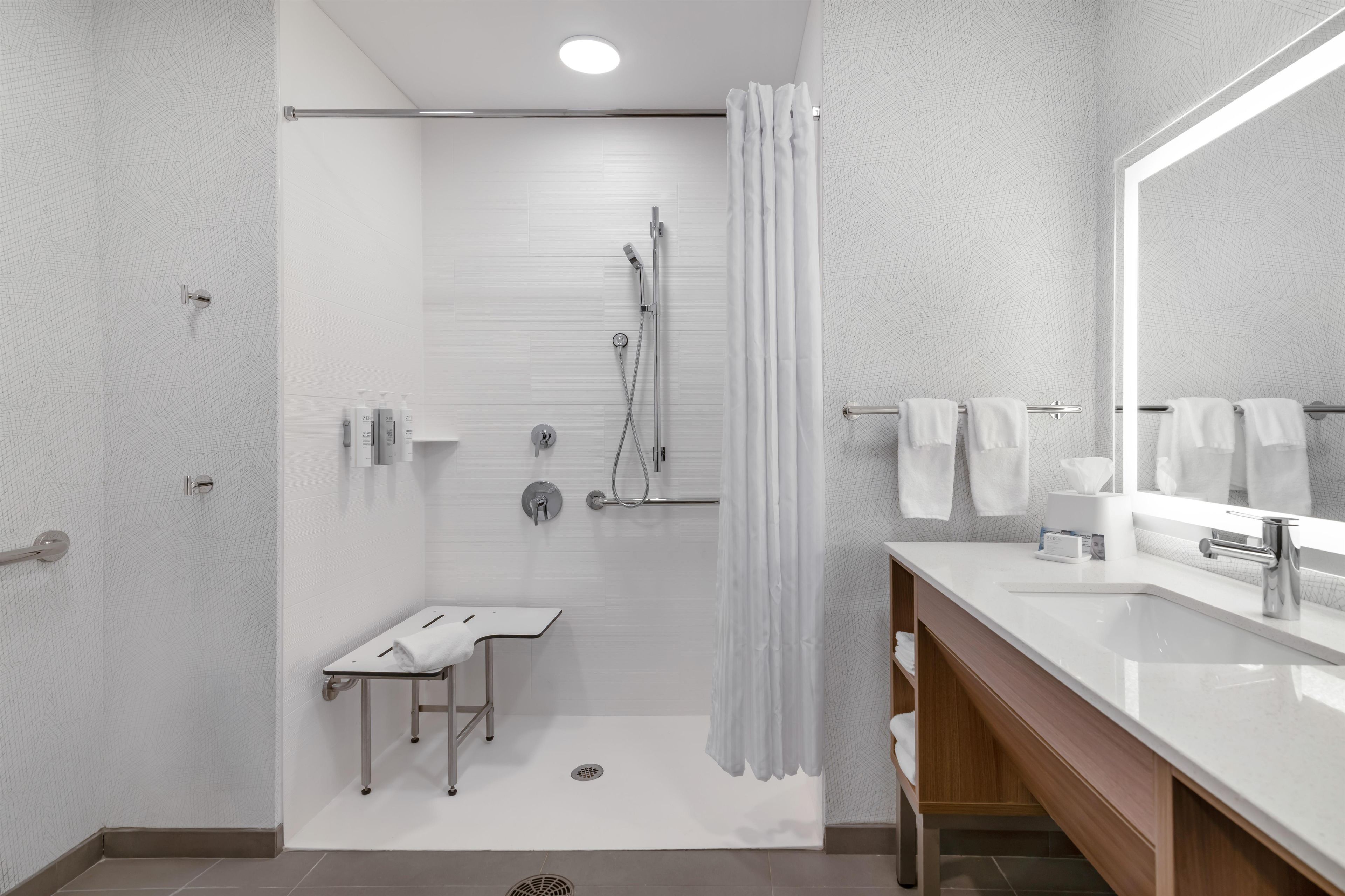 A modern bathroom with a shower, toilet, and sink.