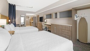 A hotel room with two beds, a desk, a chair, a TV, a wardrobe, and a bathroom. - Home2 Suites by Hilton Queensbury Lake George (Queensbury)