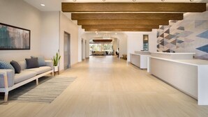 A modern reception area with a wooden ceiling, a reception desk, and a seating area with a sofa and a plant. - Residence Inn by Marriott Phoenix Chandler/South (Chandler)