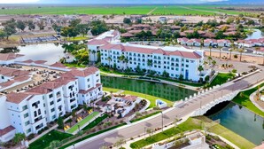 A large hotel with multiple buildings, a central courtyard, and a lake. - Residence Inn by Marriott Phoenix Chandler/South (Chandler)