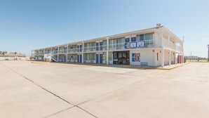 A motel with a two-story structure, a covered front area, and a parking lot. - Motel 6 Liberal, KS (Liberal)