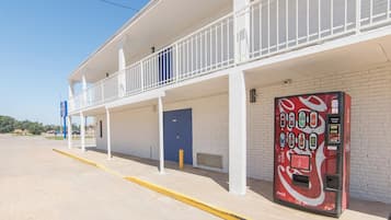 Un motel doté d’un espace extérieur abrité, d’un distributeur automatique de Coca-Cola et d’une porte bleue.