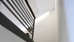 Un escalier avec des marches noires et une rampe en métal.