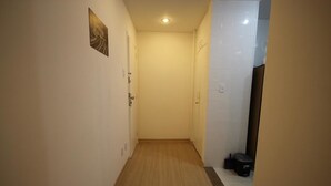 A narrow hallway with wooden flooring, white walls, and a door at the end. - GoHouse Djalma 519 (Rio de Janeiro)