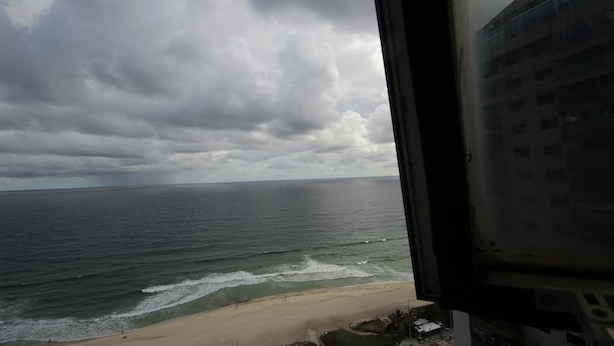 Blick auf den Ozean durch ein Fenster mit Ausblick auf einen Strand.