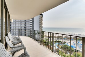 Varanda com vista para o oceano e área de resort.