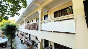 A multi-story hotel with balconies, potted plants, and outdoor seating areas. - Stardust Beach Hotel Matabungkay Batangas (Lian)