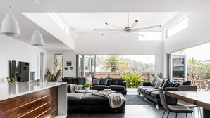En moderne stue med et træreception, en stor sofa og et spiseområde med bar.