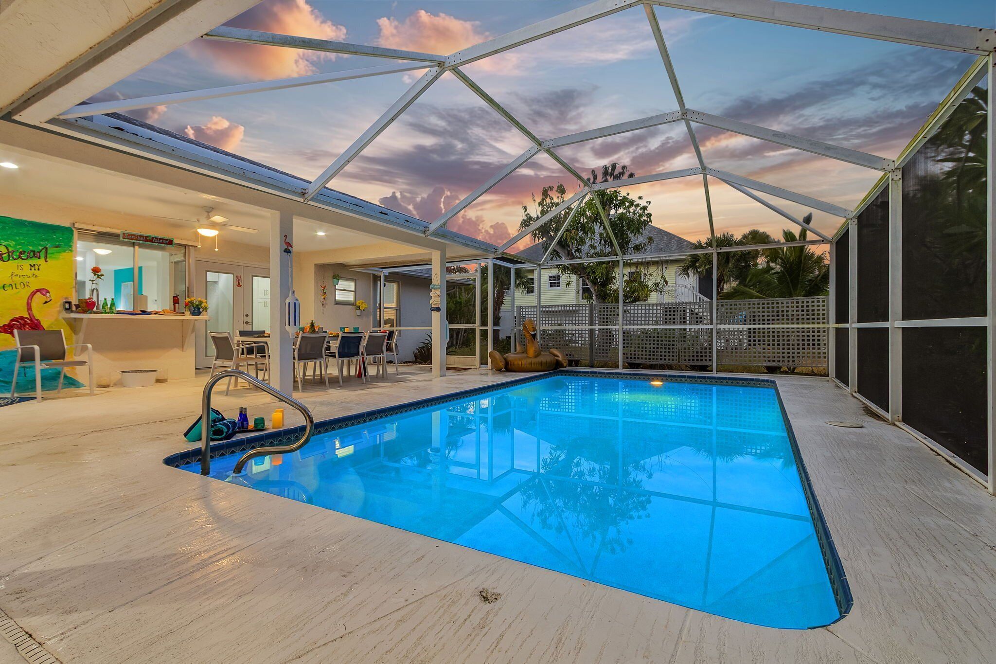 A swimming pool with a glass ceiling, surrounded by lounge chairs and a poolside bar.