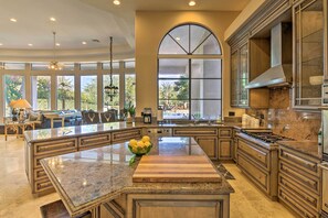 A spacious kitchen with a large island, granite countertops, and a view of the outdoors. - Lavish Paradise Valley Home w/ Sports Court & Pool (Paradise Valley)