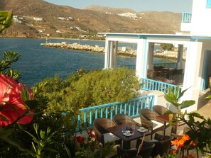 A terrace with wicker furniture and a view of the sea. - Filoxenia (Amorgos)