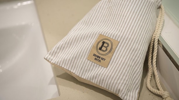 Ein gestreiftes Handtuch mit einem Etikett, auf dem 'BROWN-DOT HOTEL' steht.