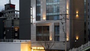 A modern hotel with a prominent sign, large windows, and a staircase leading to the entrance. - Guseo Browndot Hotel (Busan)