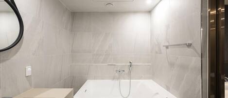 A modern bathroom with a bathtub, a sink, and a mirror.