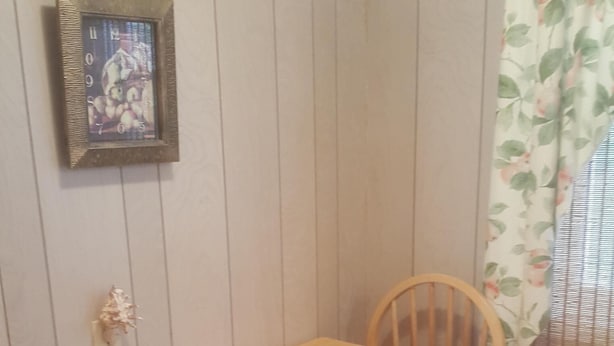 A dining area with a wooden table and four chairs. A menu is placed on the table. - Best Value in Westerly!  (Westerly)