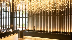 Een modern interieur met hanglampen, een receptiebalie en grote ramen.
