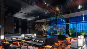 Ein moderner Loungebereich mit Sofas, Sesseln und einem Couchtisch in der Mitte.
