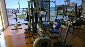 A gym with various exercise equipment, including a treadmill, stationary bike, and weight machines.