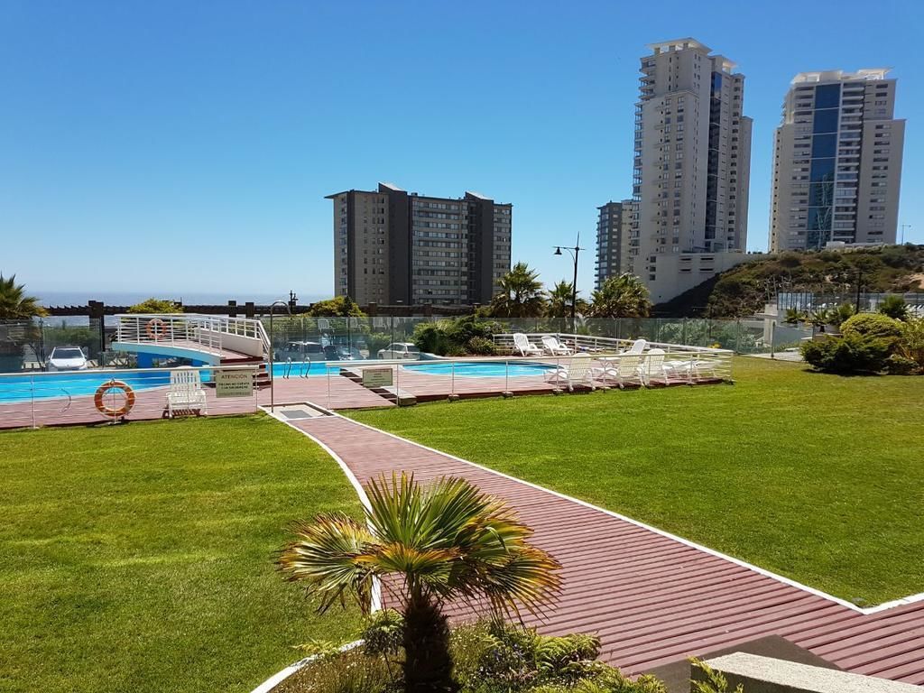 A pool area with a pathway, lounge chairs, and a lifebuoy.